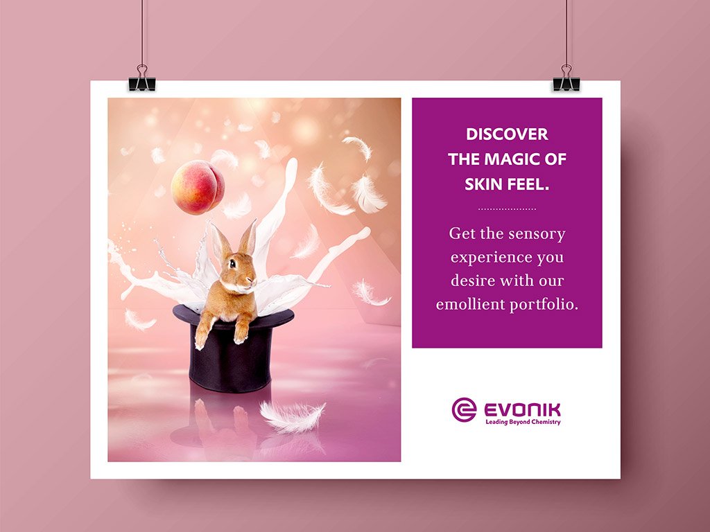 Aus einem Zauberhut kommen ein Kaninchen, ein Pfirsich und andere Dinge, die schön weich sind; Headline: „Discover the magic of skin feel.“